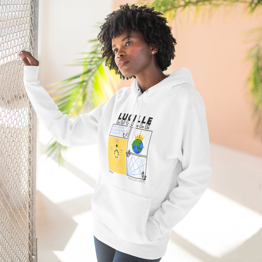woman wearing a white hoodie with a Lucille graphic design, standing against a light-colored wall with plants.